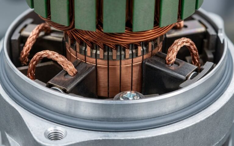 Moteur électrique ouvert avec collecteur et zone de contact des balais visibles dans un environnement industriel réaliste