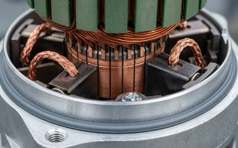 Opened electric motor with visible commutator and brush contact area in a realistic industrial setting